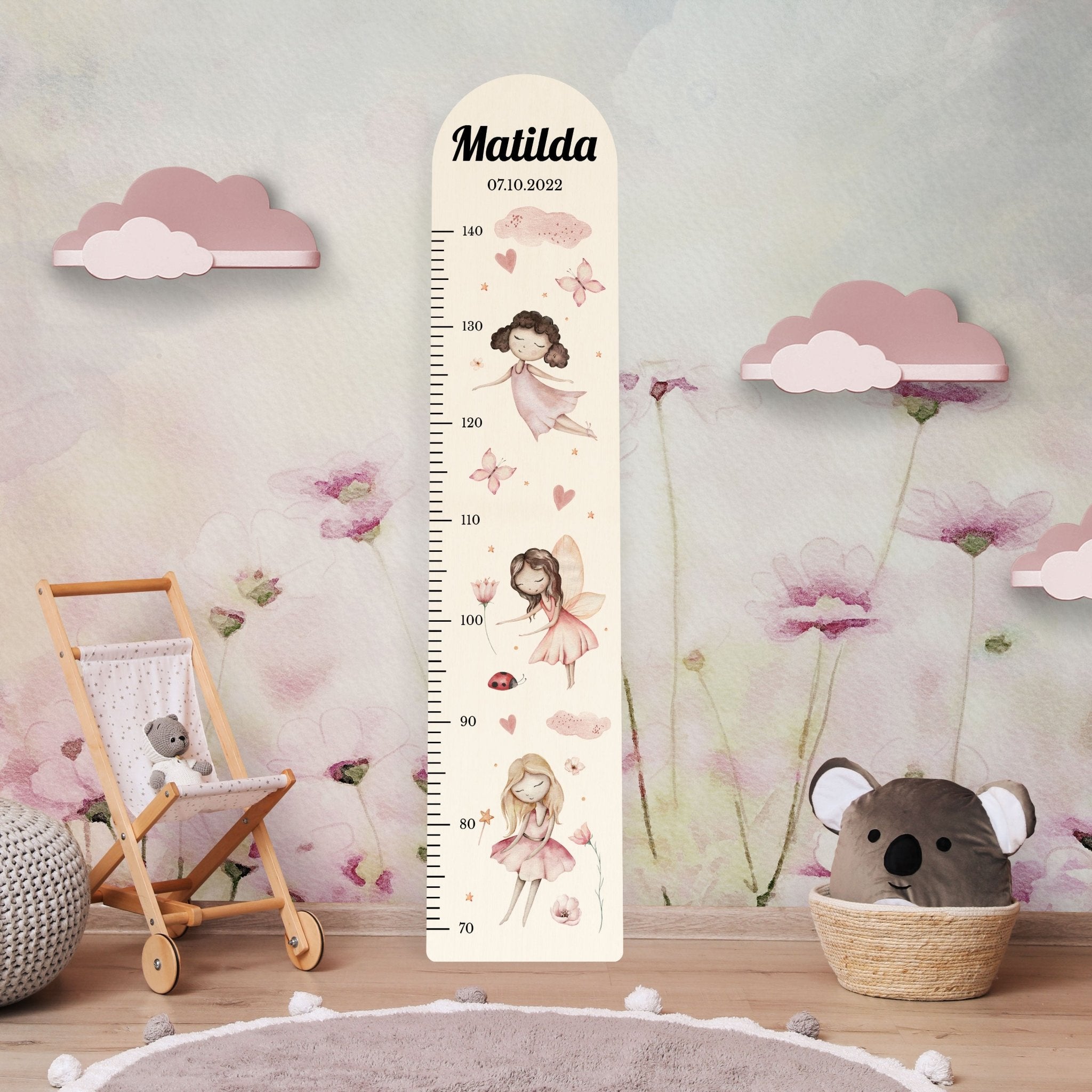 Personalisierte Messlatte aus Holz für Mädchen mit Feen vor einer Kinderzimmerwand. Personalisierte Messlatte aus Holz für Mädchen mit Feen vor einer Kinderzimmerwand.