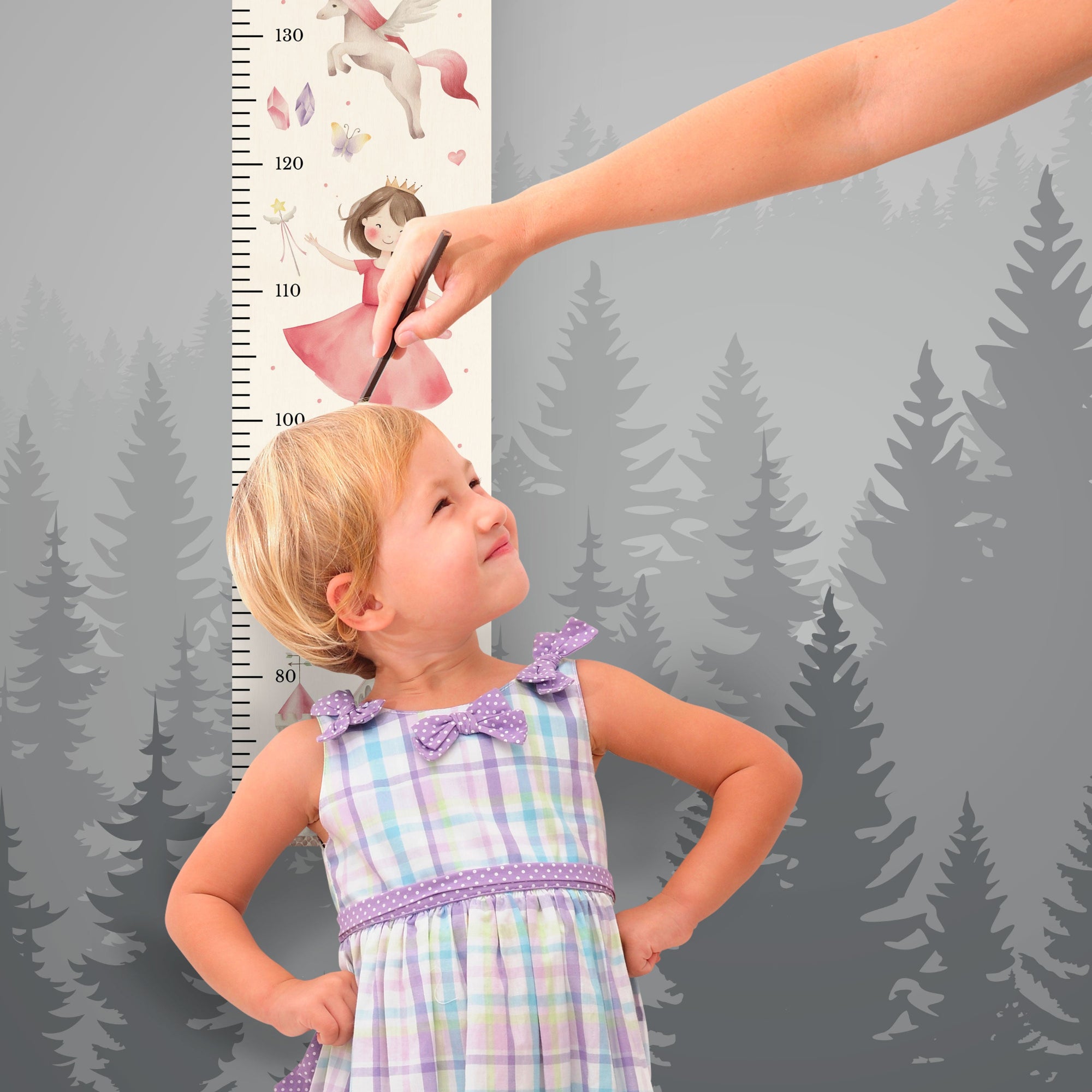 Mädchen steht vor der personalisierten Messlatte und misst ihre Größe. Mädchen steht vor der personalisierten Messlatte und misst ihre Größe.