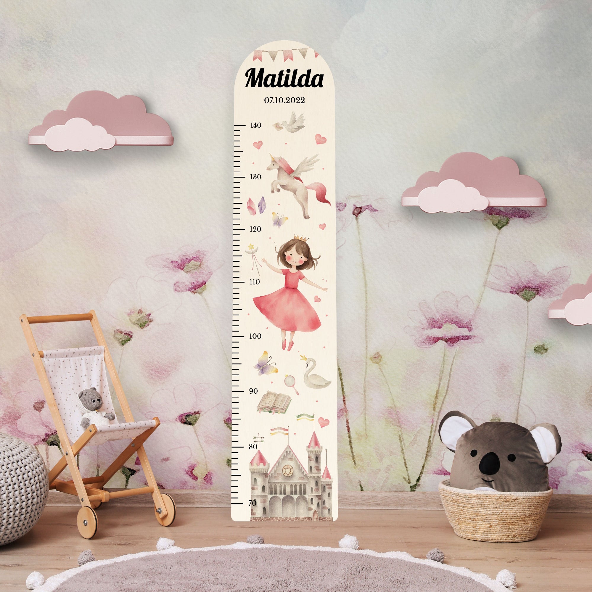 Personalisierte Messlatte aus Holz für Mädchen mit Prinzessin und Einhorn Motiv vor einer Kinderzimmerwand.