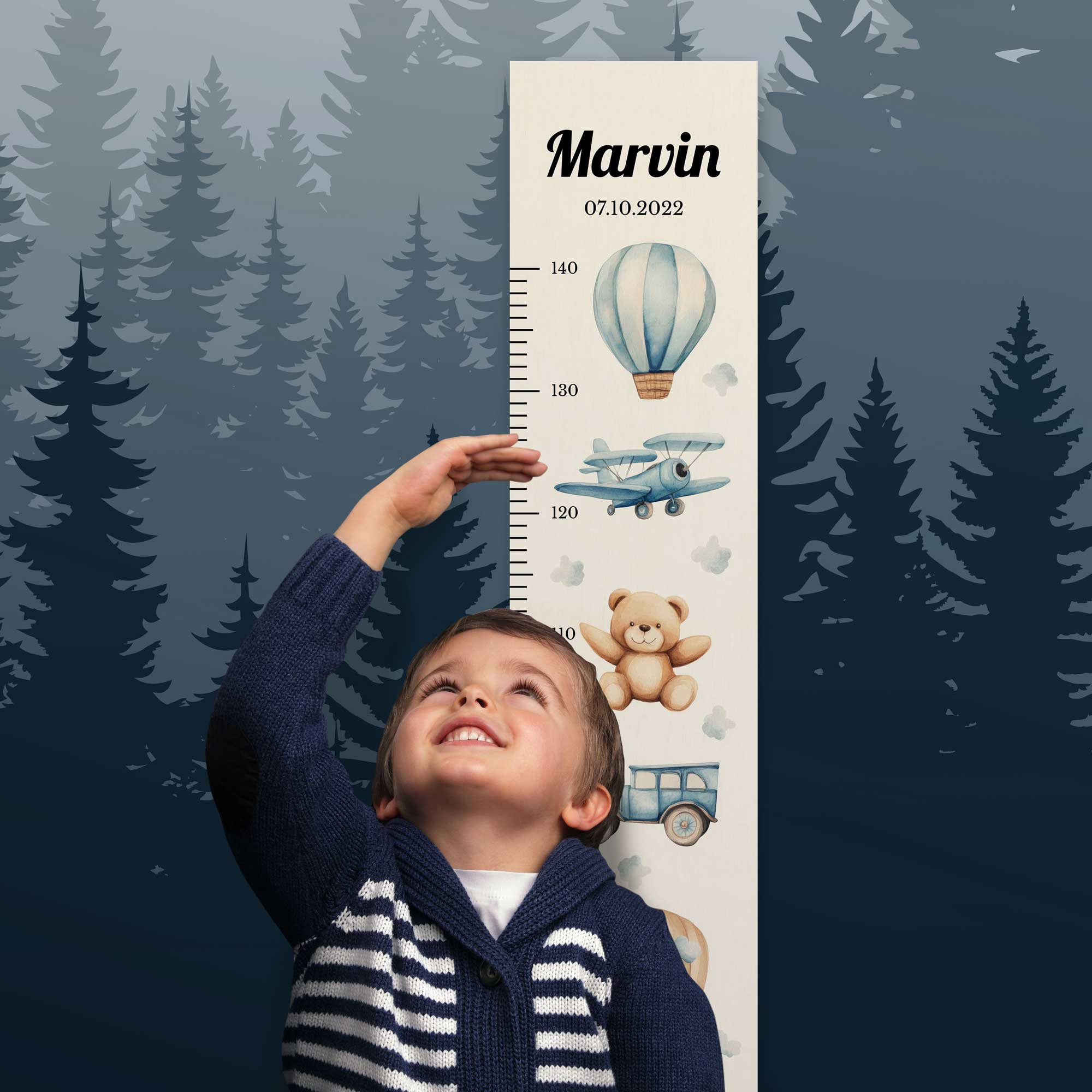 Junge steht vor der personalisierten Messlatte und misst seine Größe.