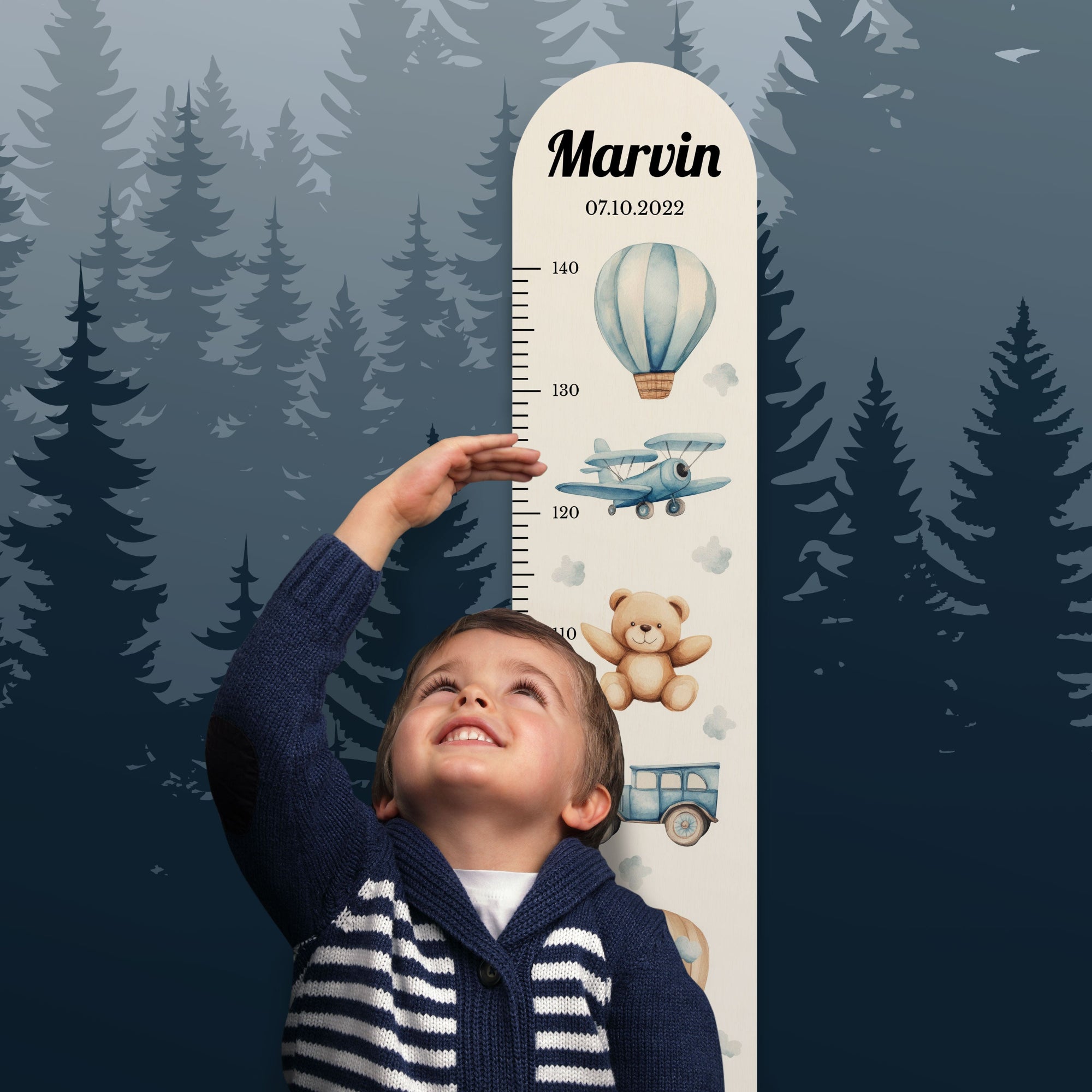 Junge steht vor der personalisierten Messlatte und misst seine Größe.